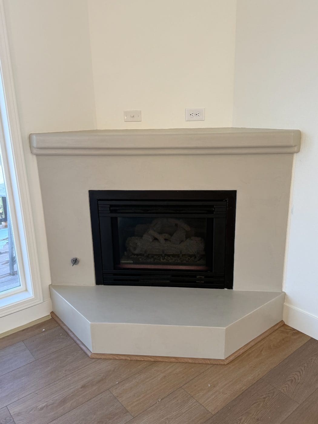 Corner fireplace surround finished in microcement